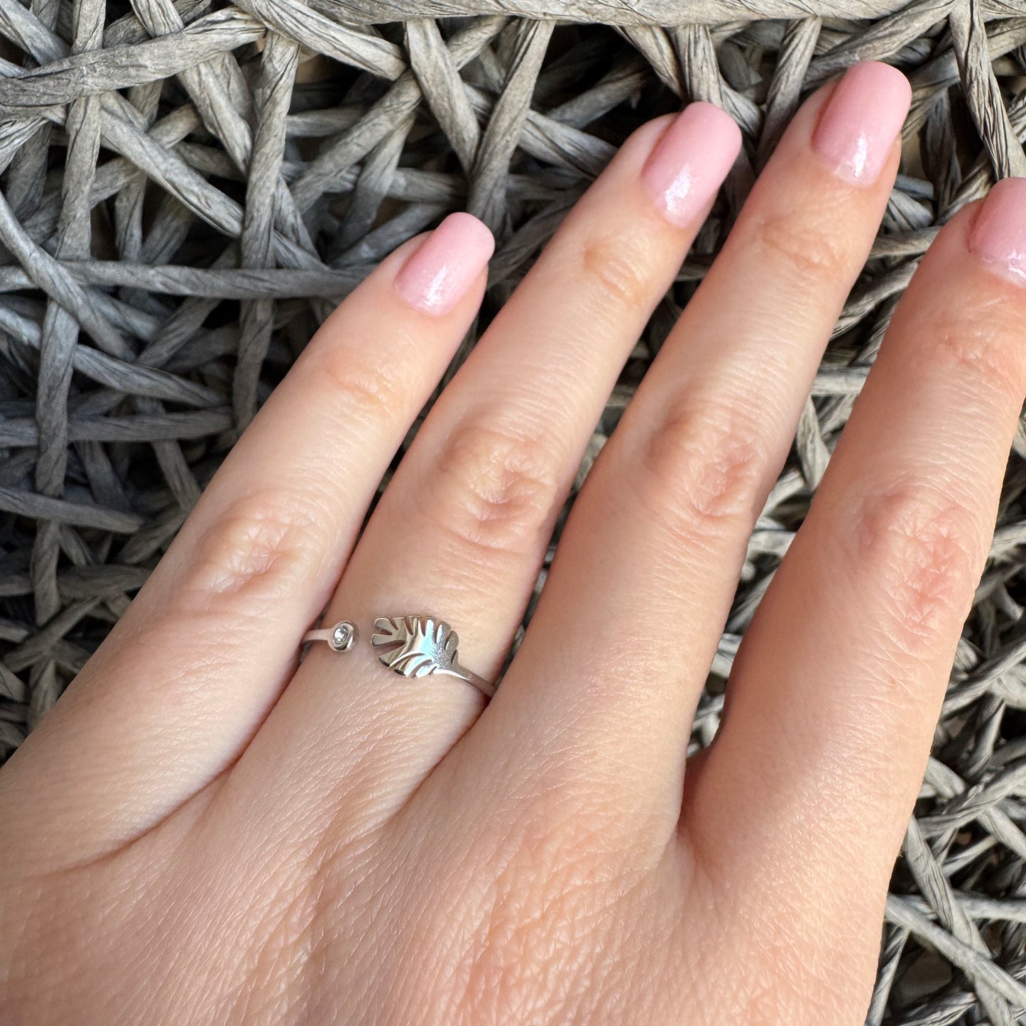 Open stainless steel IRL ring with leaf motif and tiny zircon worn on finger