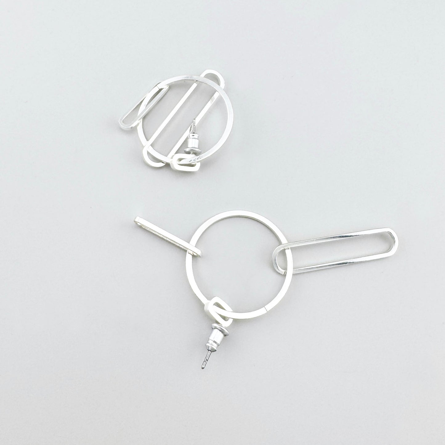 Pendientes geométricos Pilgrim con aro y barra tipo clip, brillo pulido y trazo industrial