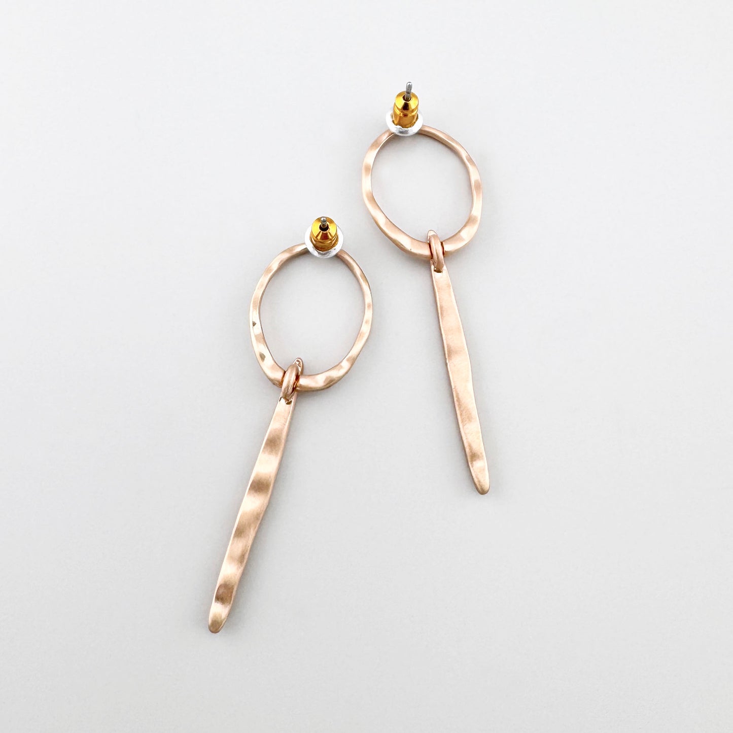 Créoles longues Pilgrim dorées, texture martelée discrète et petit cristal en terminaison