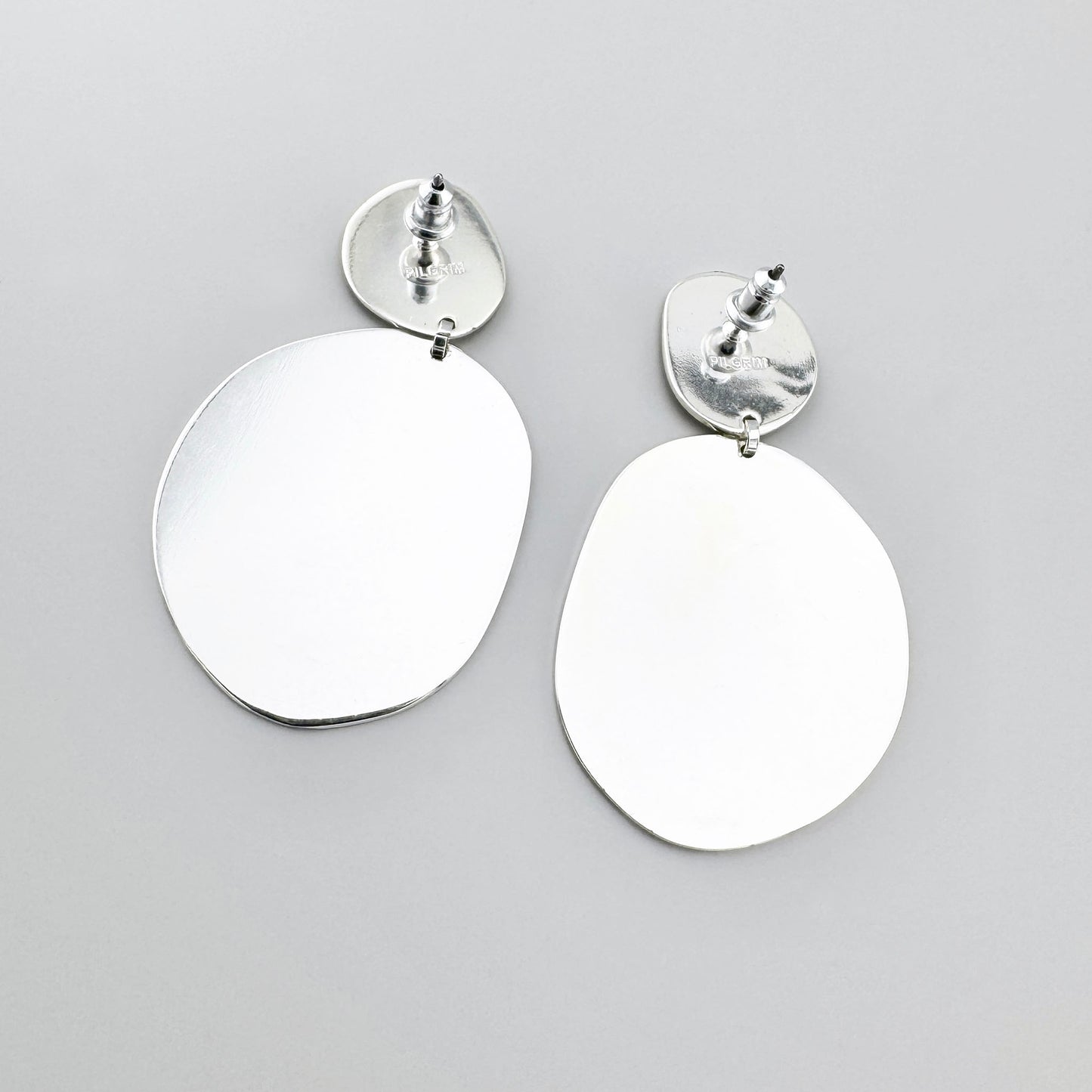 Pendientes ovalados irregulares Pilgrim con dos discos lisos que reflejan la luz con sutileza