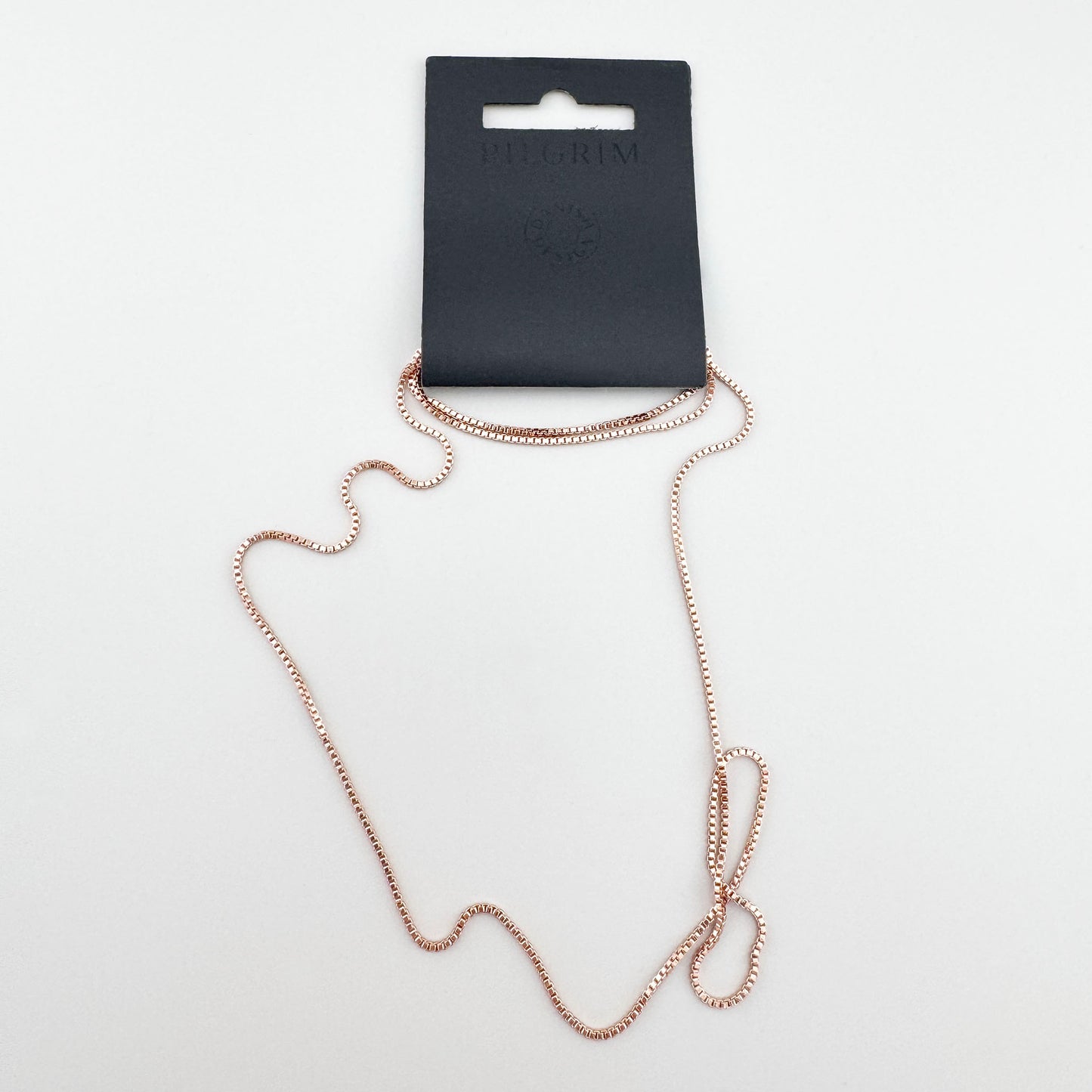 Collier minimaliste Pilgrim en or rose présenté dans l’emballage de la marque