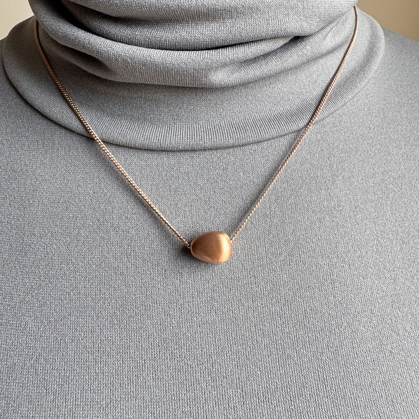 Rose gold Pilgrim necklace with soft matte oval pendant worn delicately