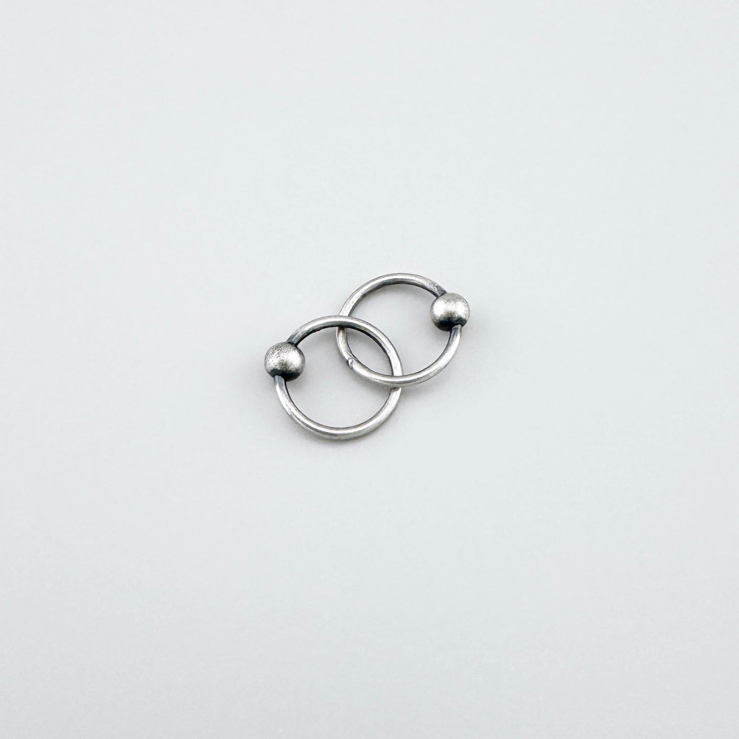 Elegant LULU Copenhagen silver piercer hoops with small polished ball detail