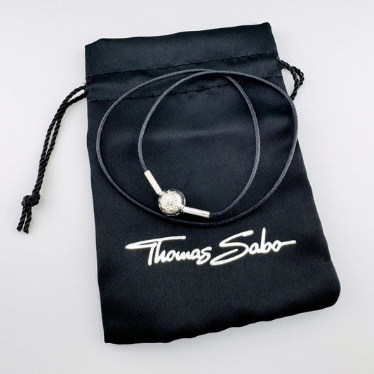 Black cord choker by Thomas Sabo with a silver compass bead displayed on a branded pouch