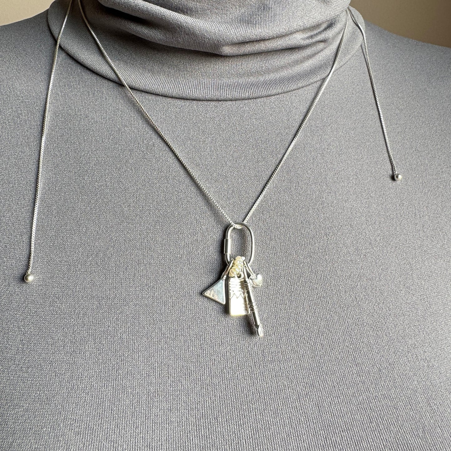 Silver Pilgrim necklace with multiple charms worn as a layered look