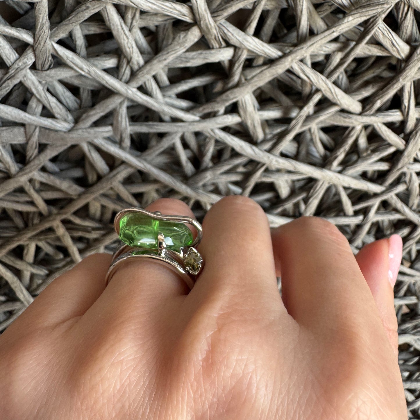 Bague argentée avec pierre verte portée de manière bohème