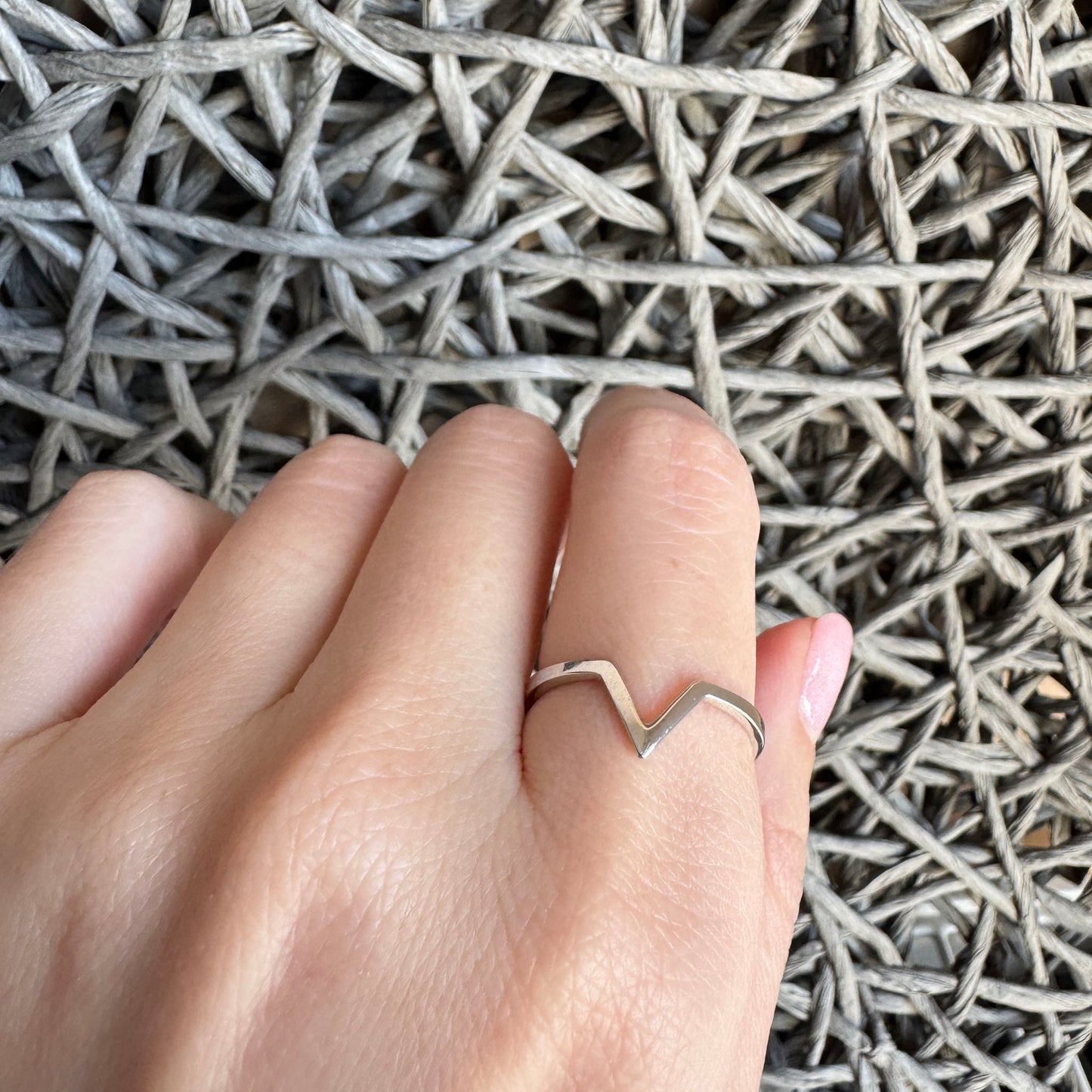 Minimalist silver V-shaped ring with polished surface and sleek design