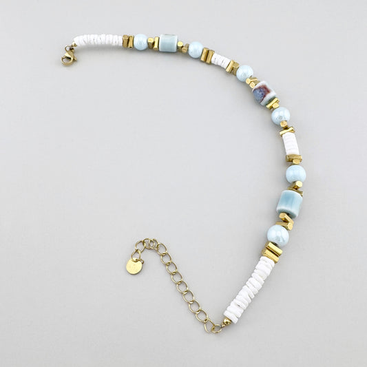 Letnia bransoletka na kostkę z błękitno-białymi koralikami ceramicznymi i złotym łańcuszkiem, francuska marka Ikita.