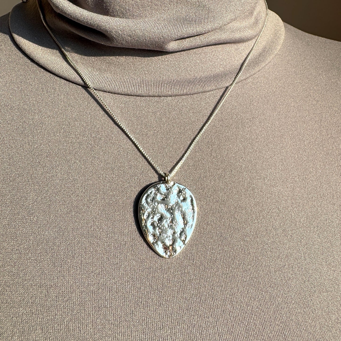 Pilgrim necklace with large textured medallion in silver tone worn on the neck