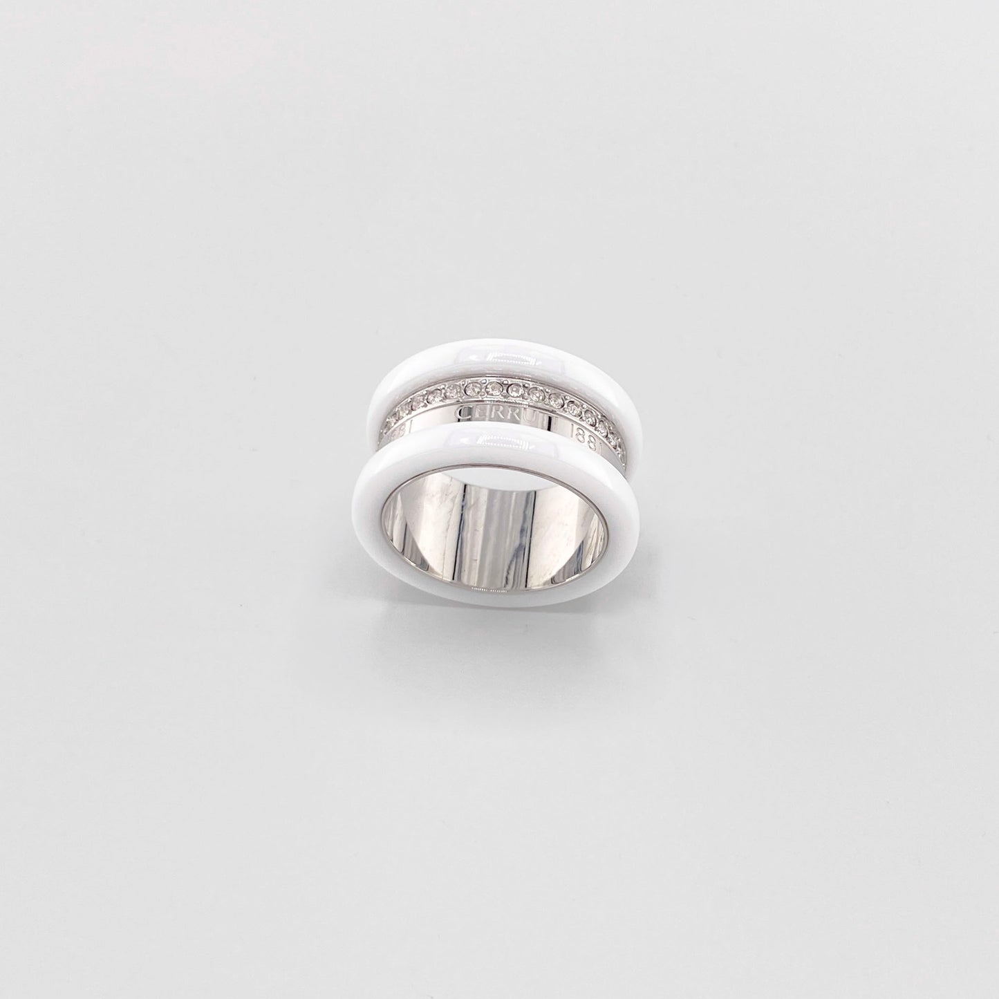 White ceramic ring by Cerruti 1881 with a wide band, silver-tone detailing, and engraved logo