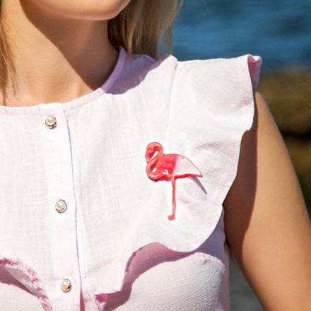 Flamingo-Brosche aus Acryl auf weißer Sommerbluse
