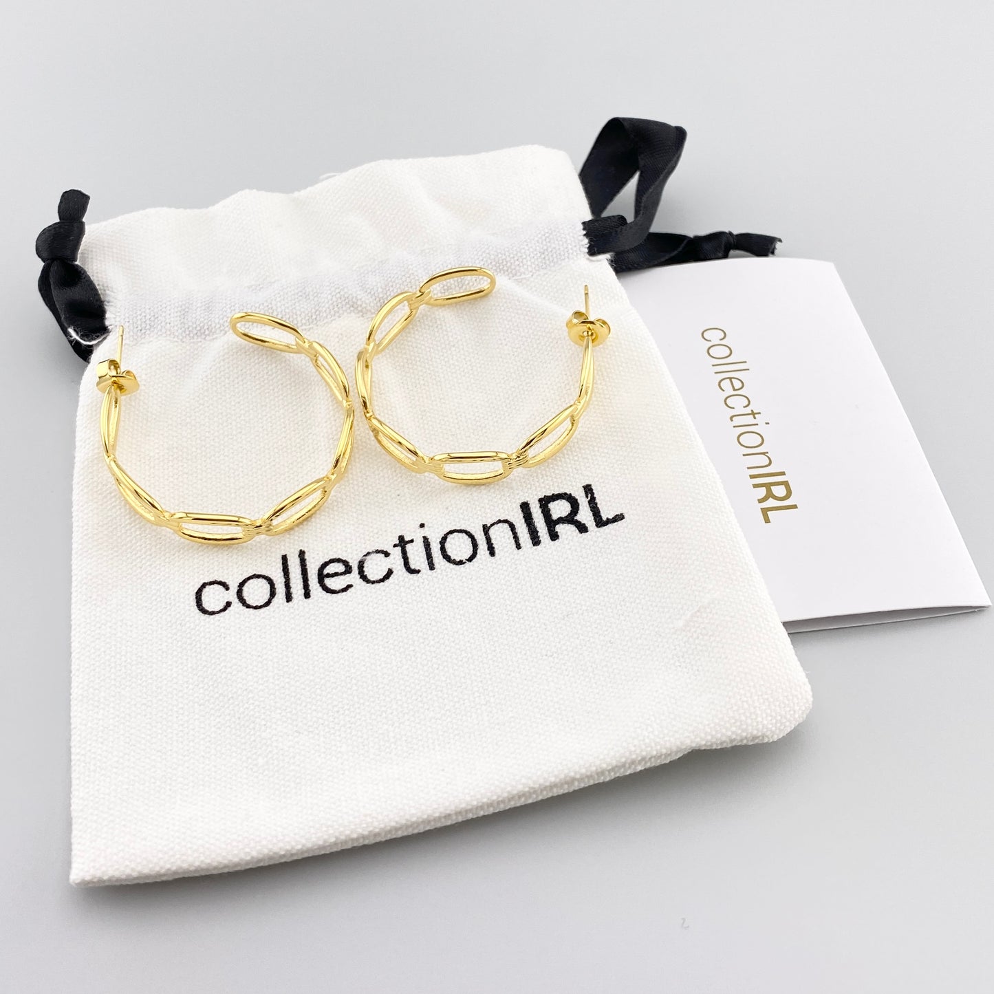 Boucles d’oreilles IRL dorées en forme de chaîne dans l’écrin de la marque