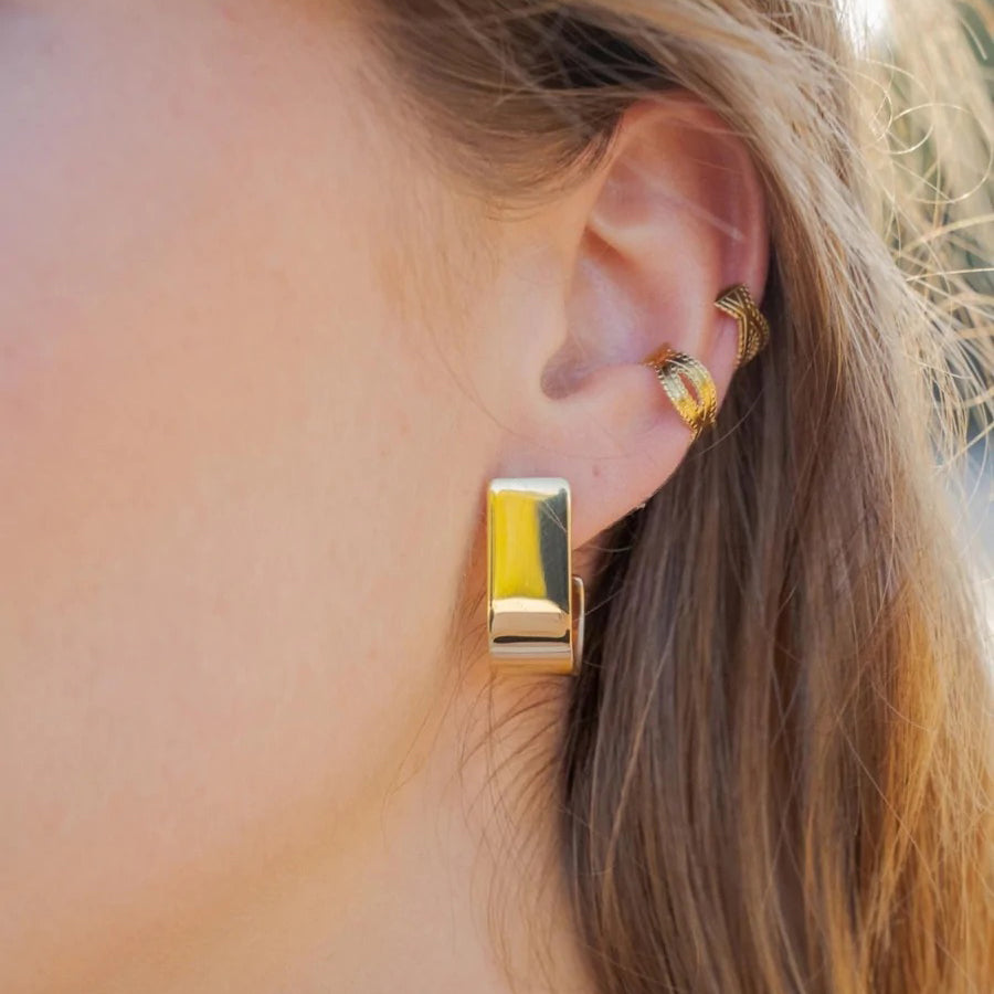 Gold-plated clip earrings with carved pattern worn on the ear
