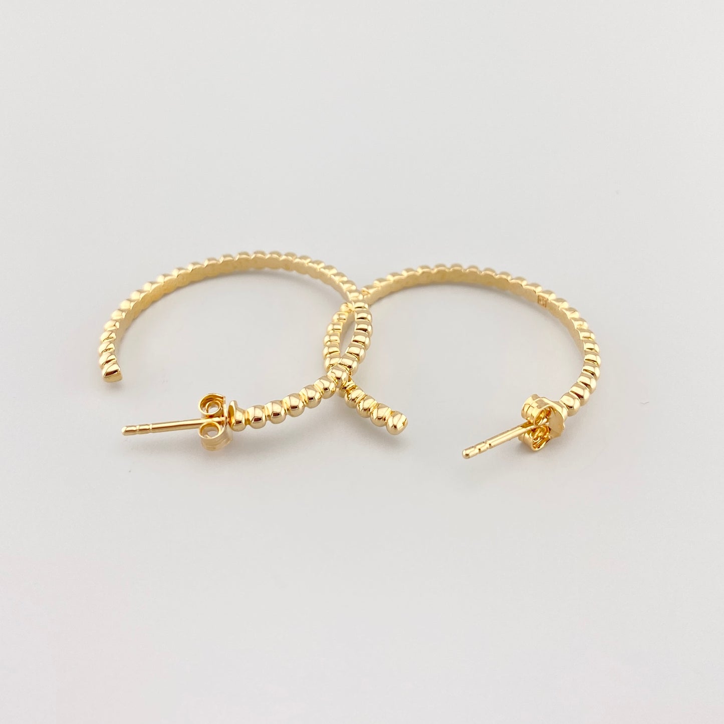 Aros dorados calados con textura en primer plano