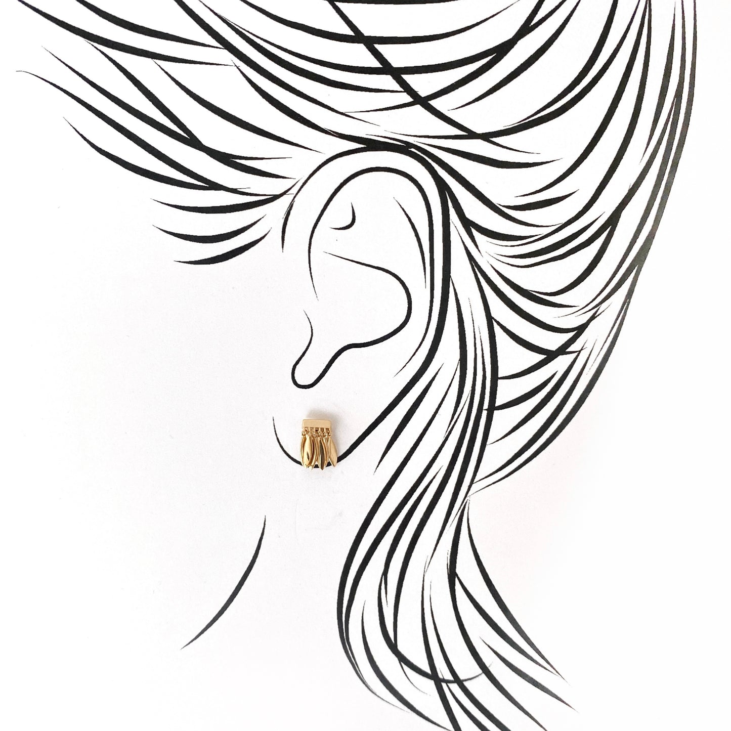 Tiny gold-plated leaf earrings gently dangling from the earlobe