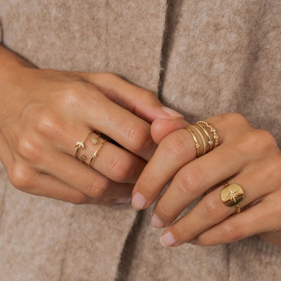 Gold IRL ring with star and crystal detail worn gracefully on hand