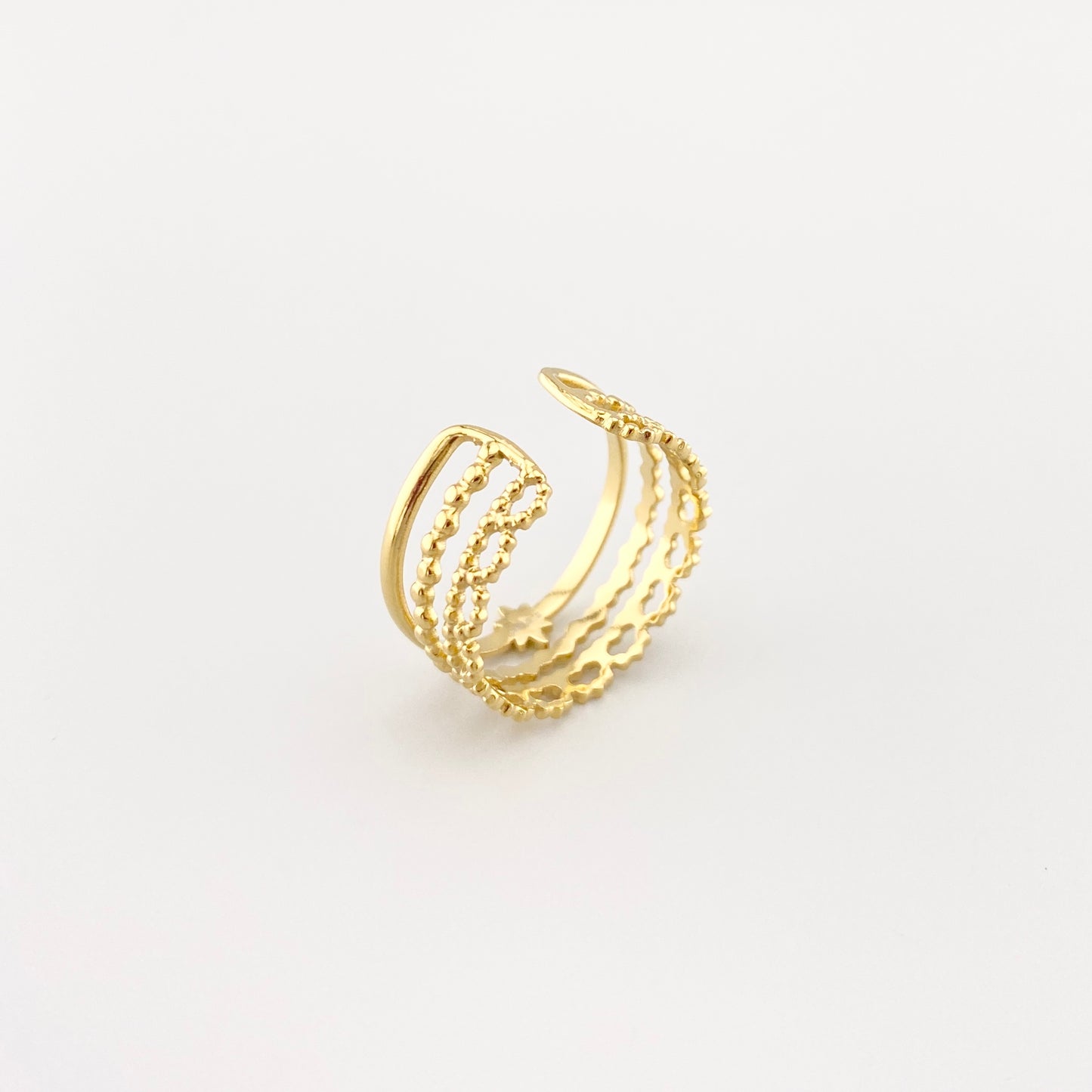 Anillo triple IRL dorado con estrella sobre fondo claro