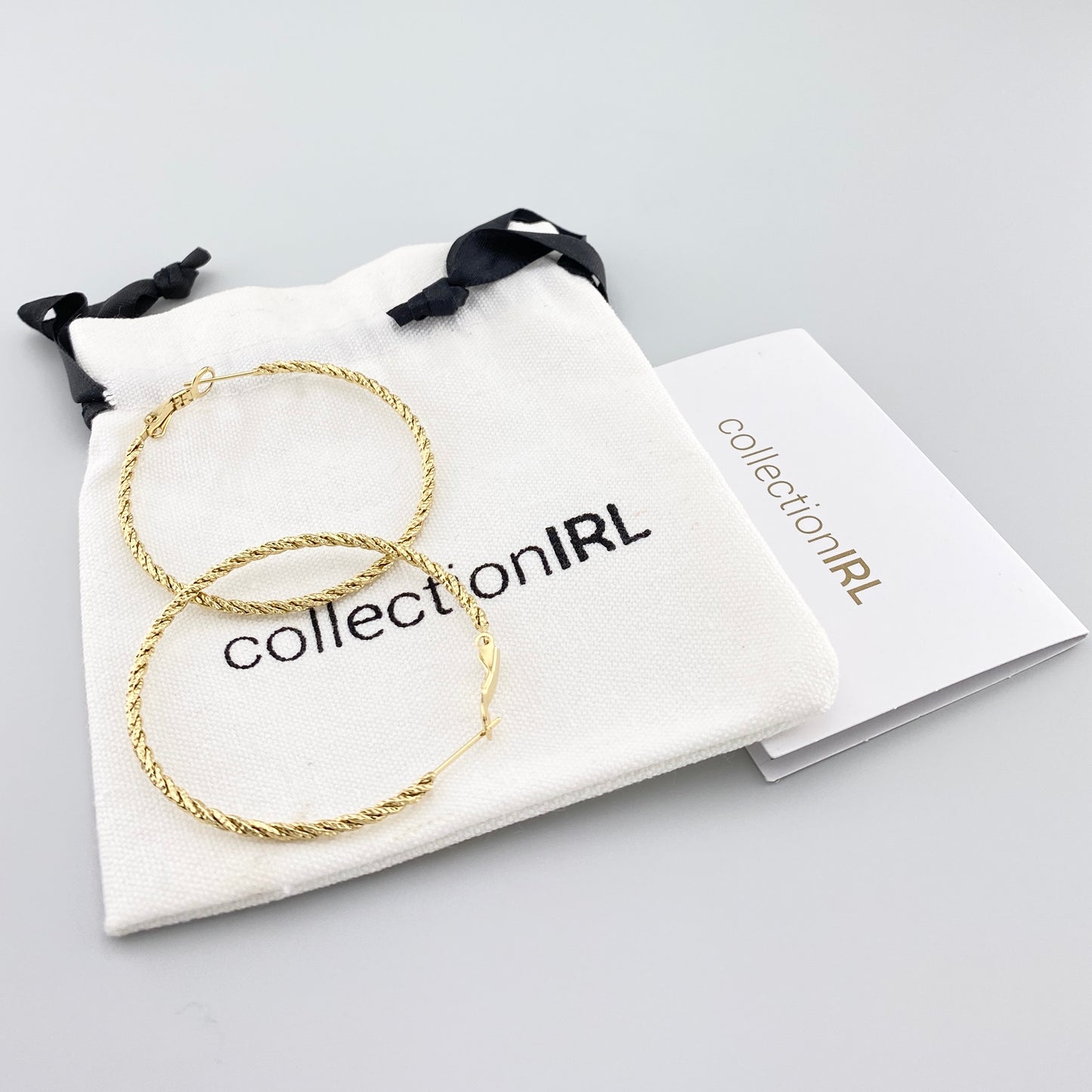 Pendientes dorados con textura trenzada y bolsa de la marca IRL