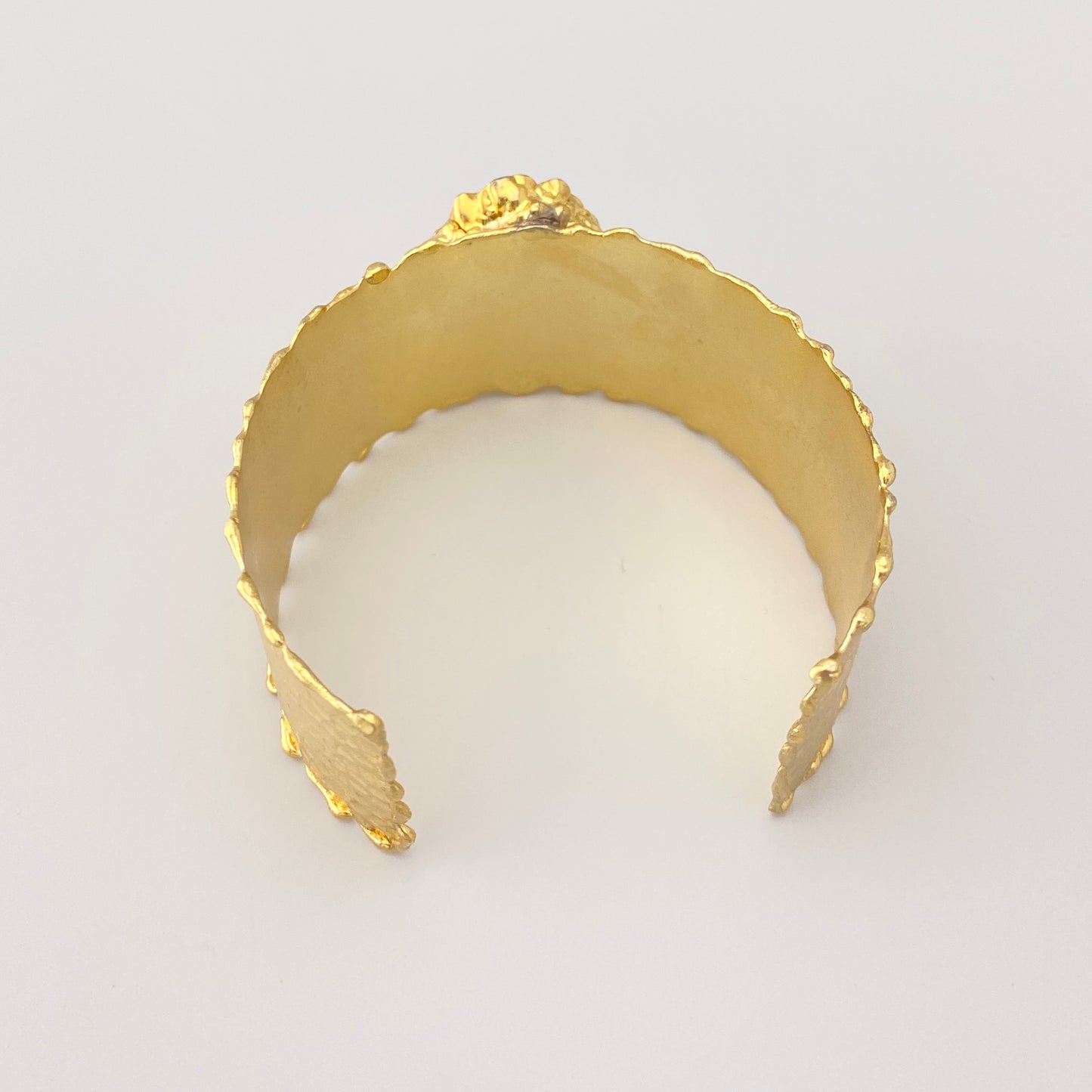Brazalete dorado con turmalina rosa-violeta y diseño expresivo artesanal