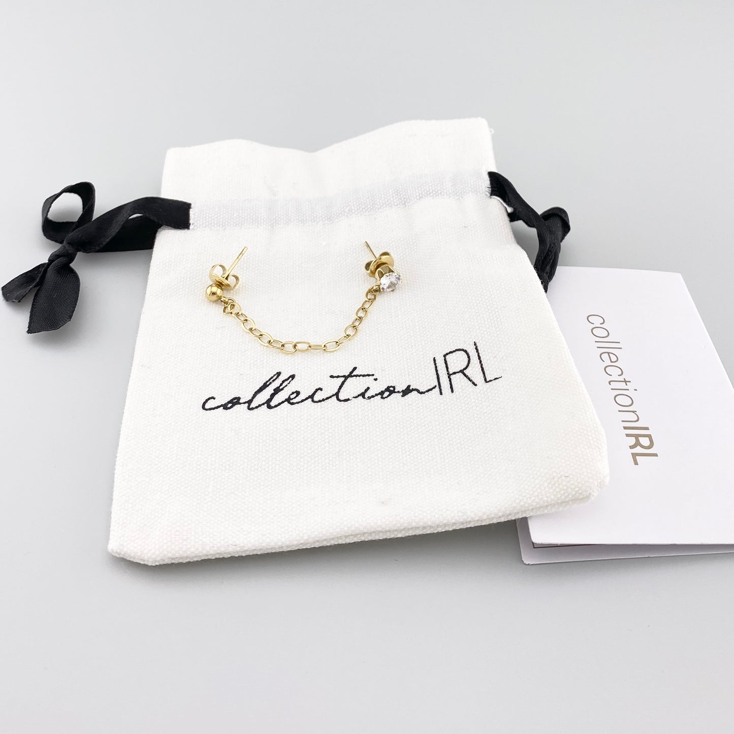 IRL mono chain earring in gold tone with sparkling zirconia, designed to link two piercings