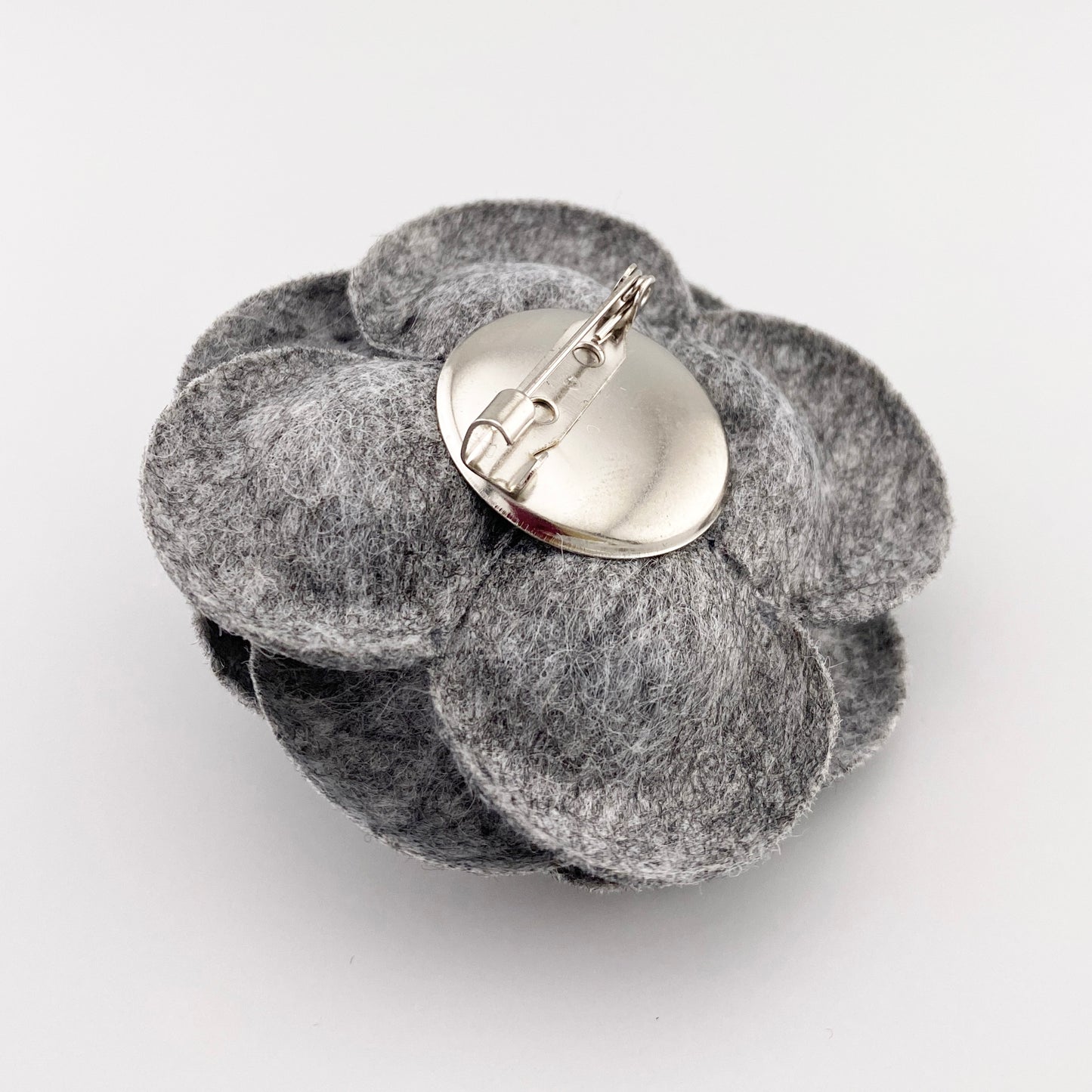 Broche gris de fieltro con cierre clásico y diseño floral