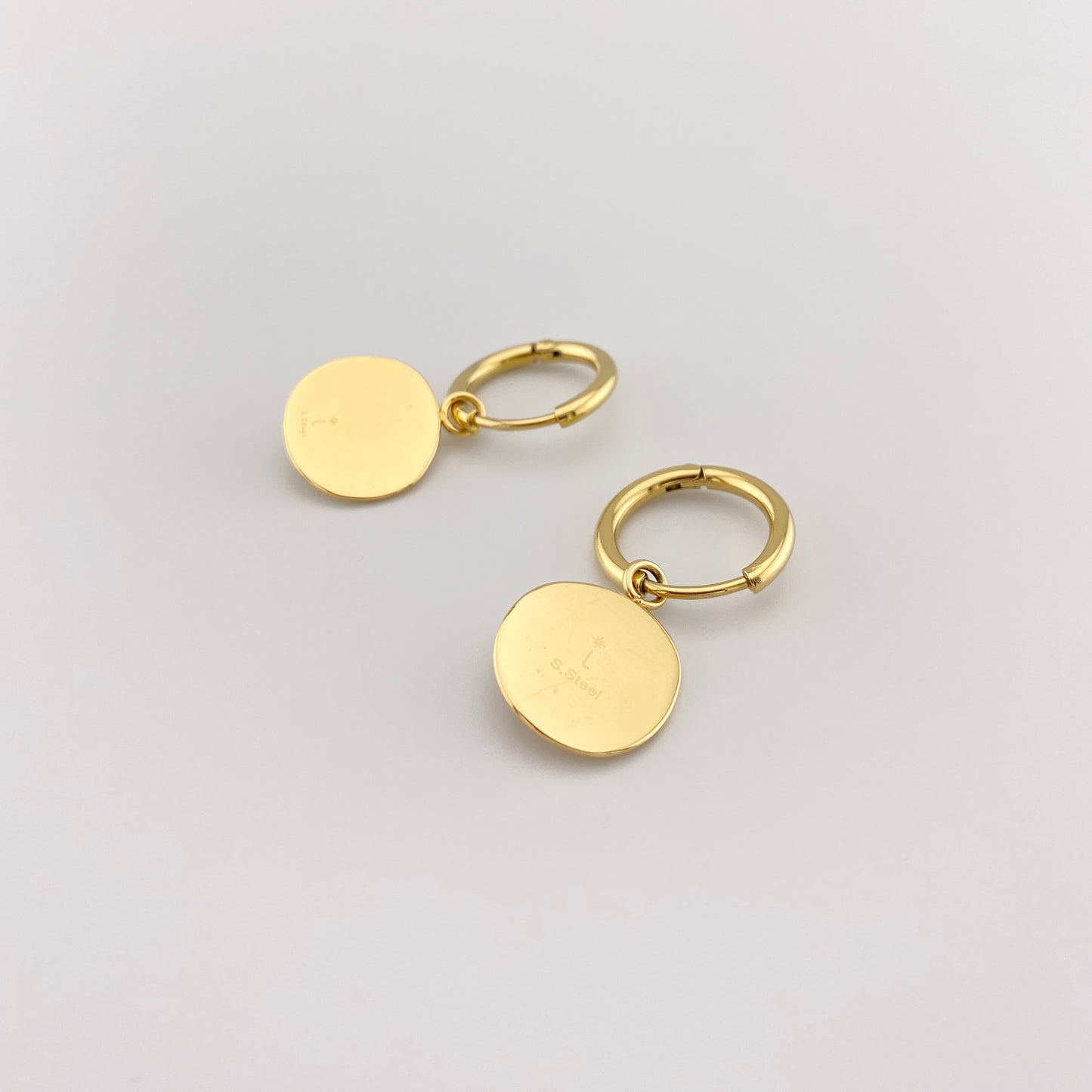 Aros IRL con medallón estrella y circonita, acabado espejo y gesto elegante