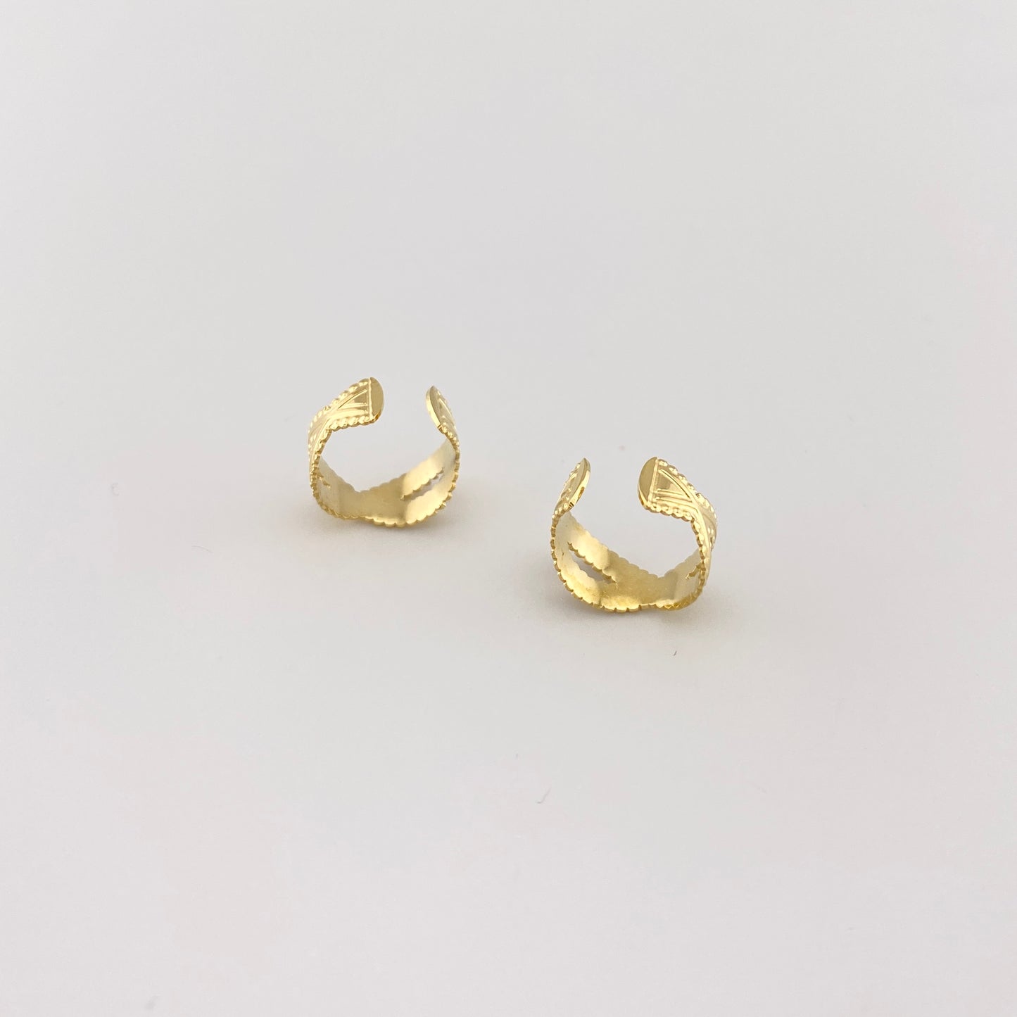 Créoles clips dorées avec motif sculpté et lignes géométriques