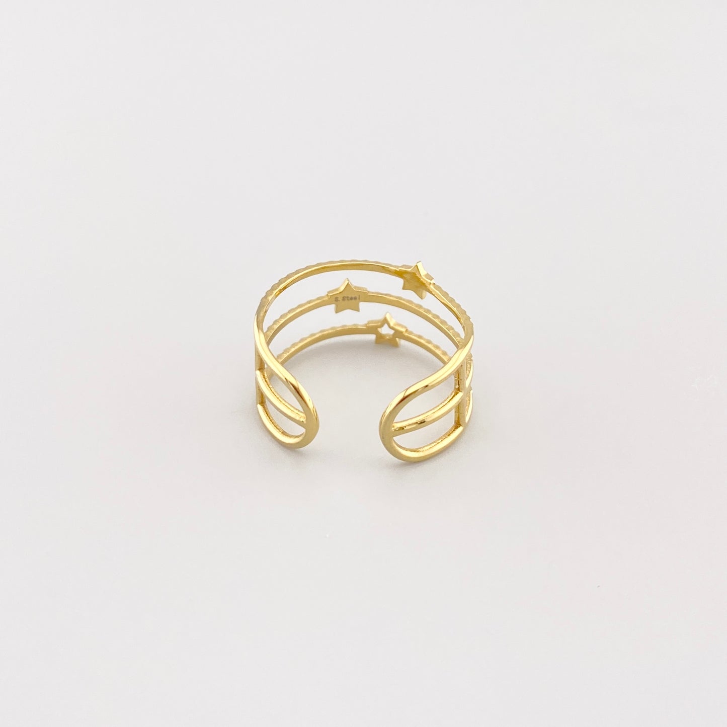 Anillo triple IRL dorado con textura y estrellas visto de arriba