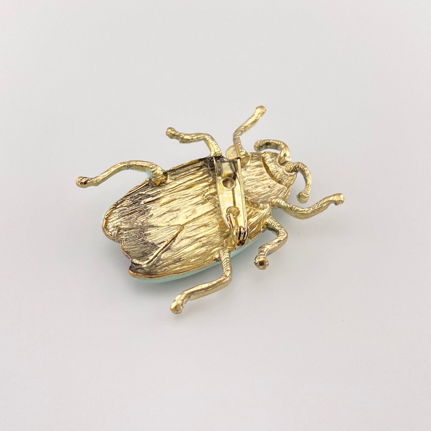Broche vintage en forme de scarabée avec texture dorée et corps en métal