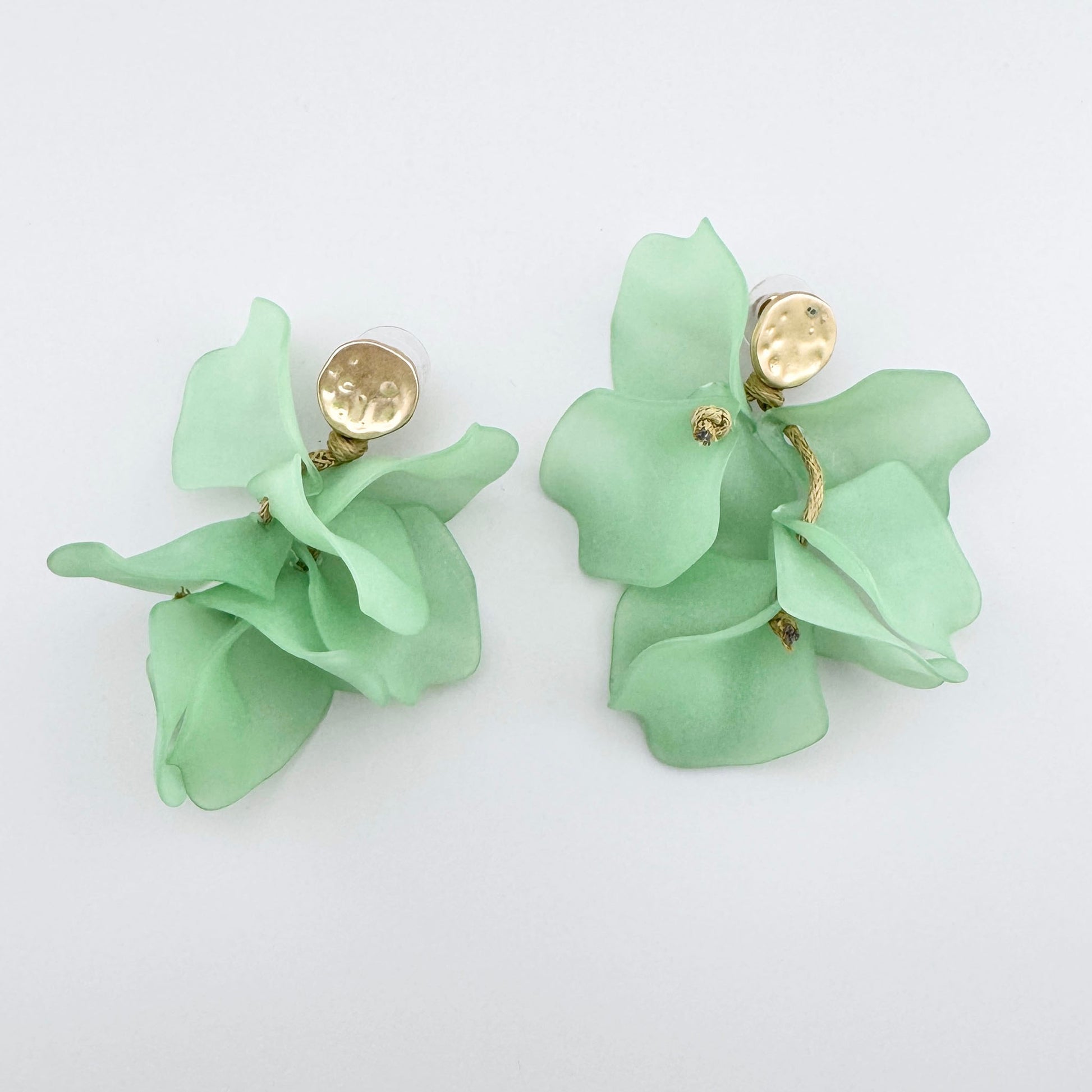 Dangling earrings with mint flower petals and gold accents.