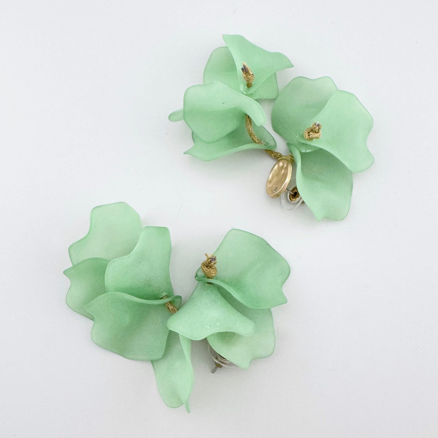 Pendientes colgantes con pétalos de flores menta y detalles dorados.