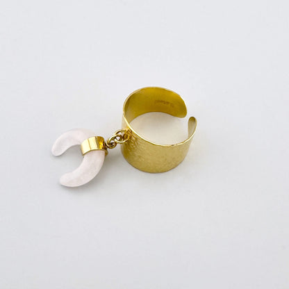 Anillo dorado con banda ancha martillada y colgante de cuarzo rosa en forma de media luna, marca francesa Ikita.