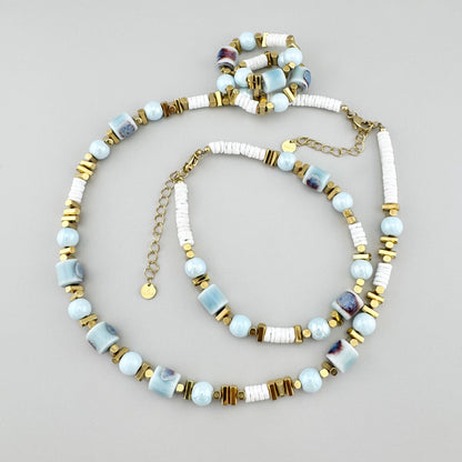 Collar con cuentas cerámicas azules, discos blancos y separadores dorados, marca francesa Ikita.