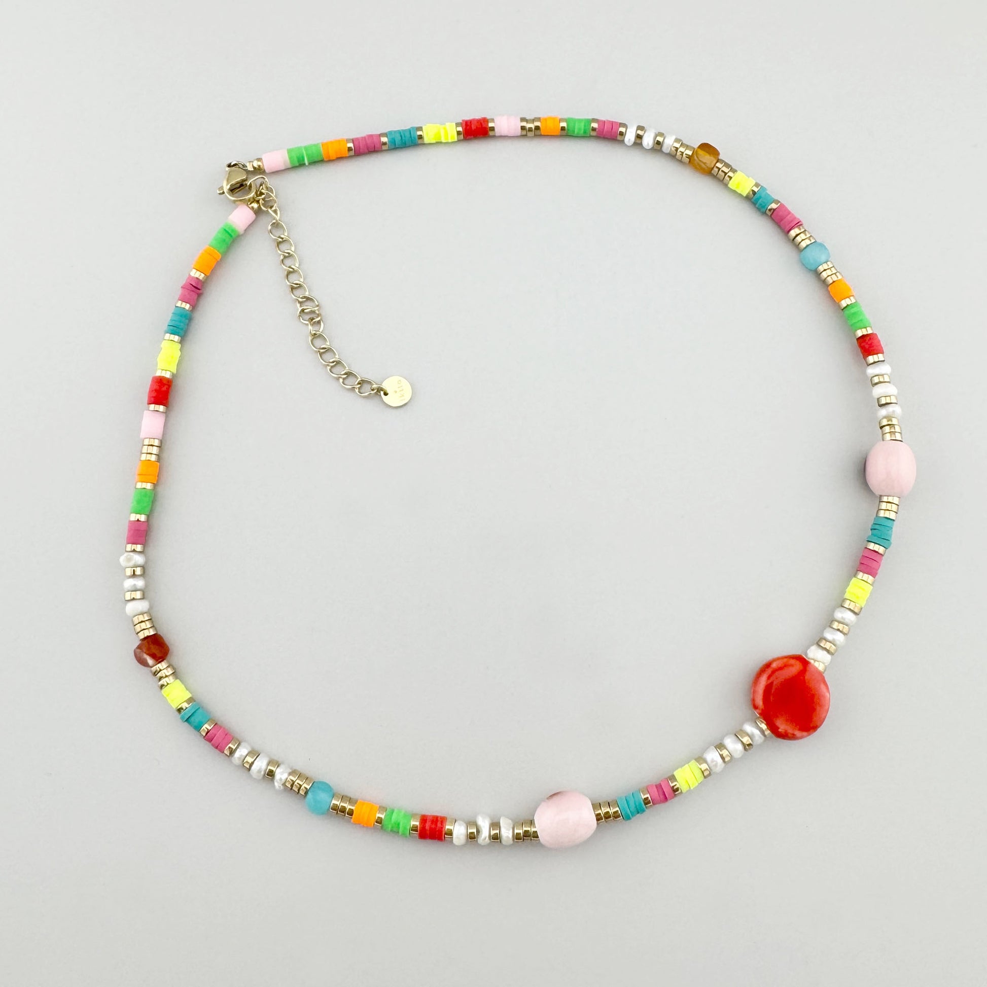Collier de perles colorées avec une perle centrale en céramique rouge, marque française Ikita.