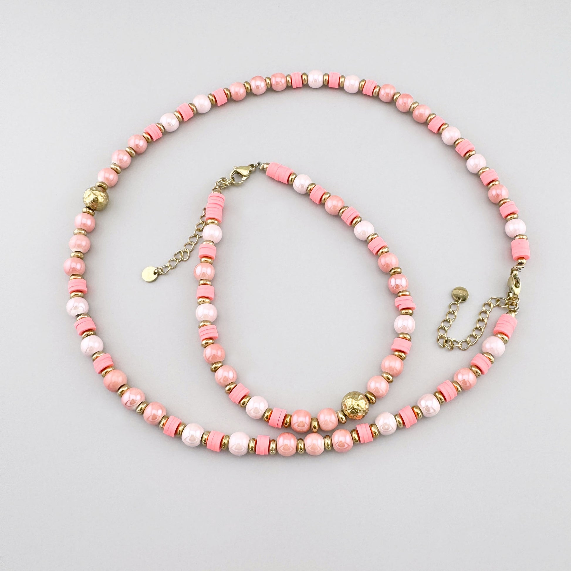 Collar con cuentas cerámicas rosadas tipo perlas y detalle dorado central, marca francesa Ikita.