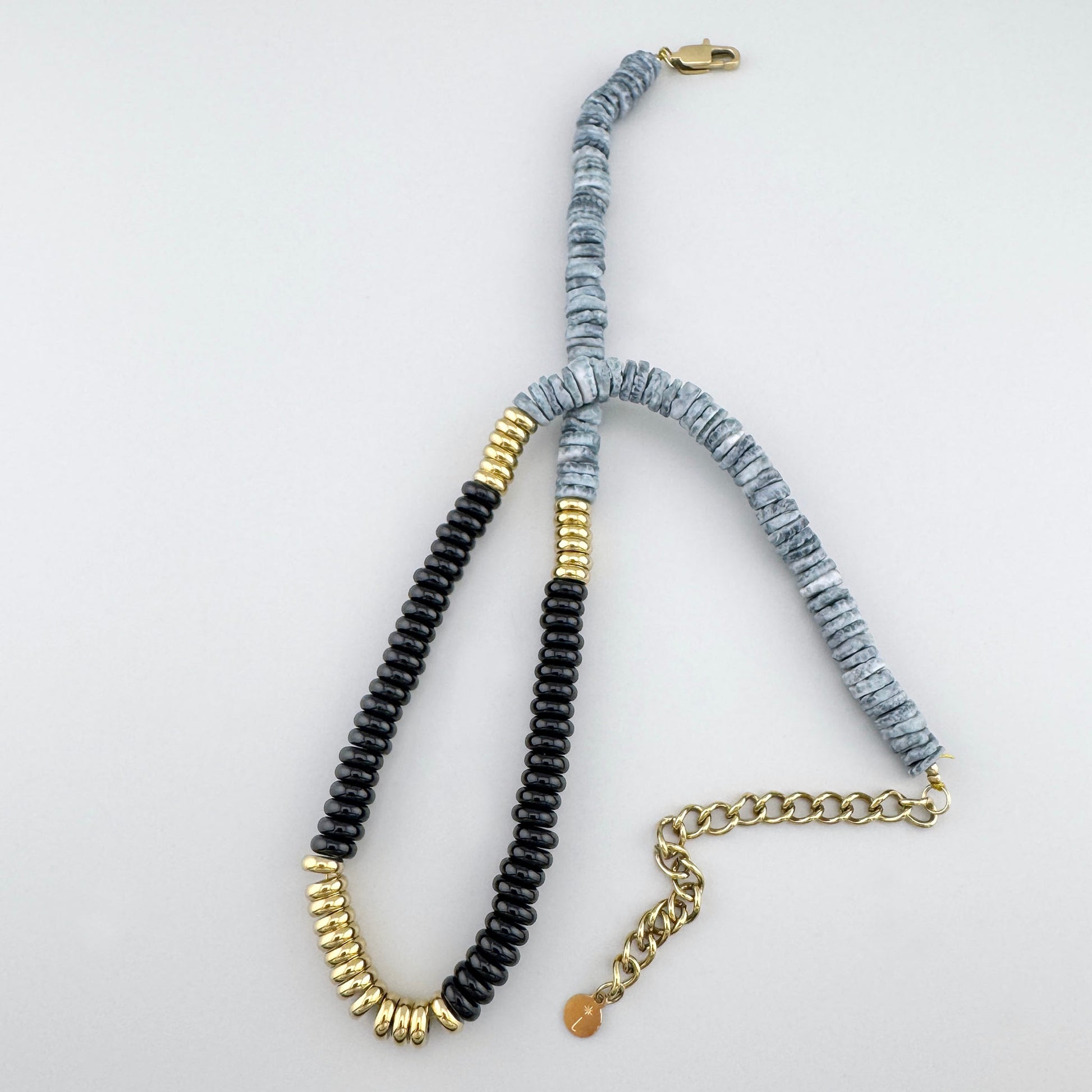 Collier avec disques en céramique gris et noir et accents dorés, marque française Ikita.