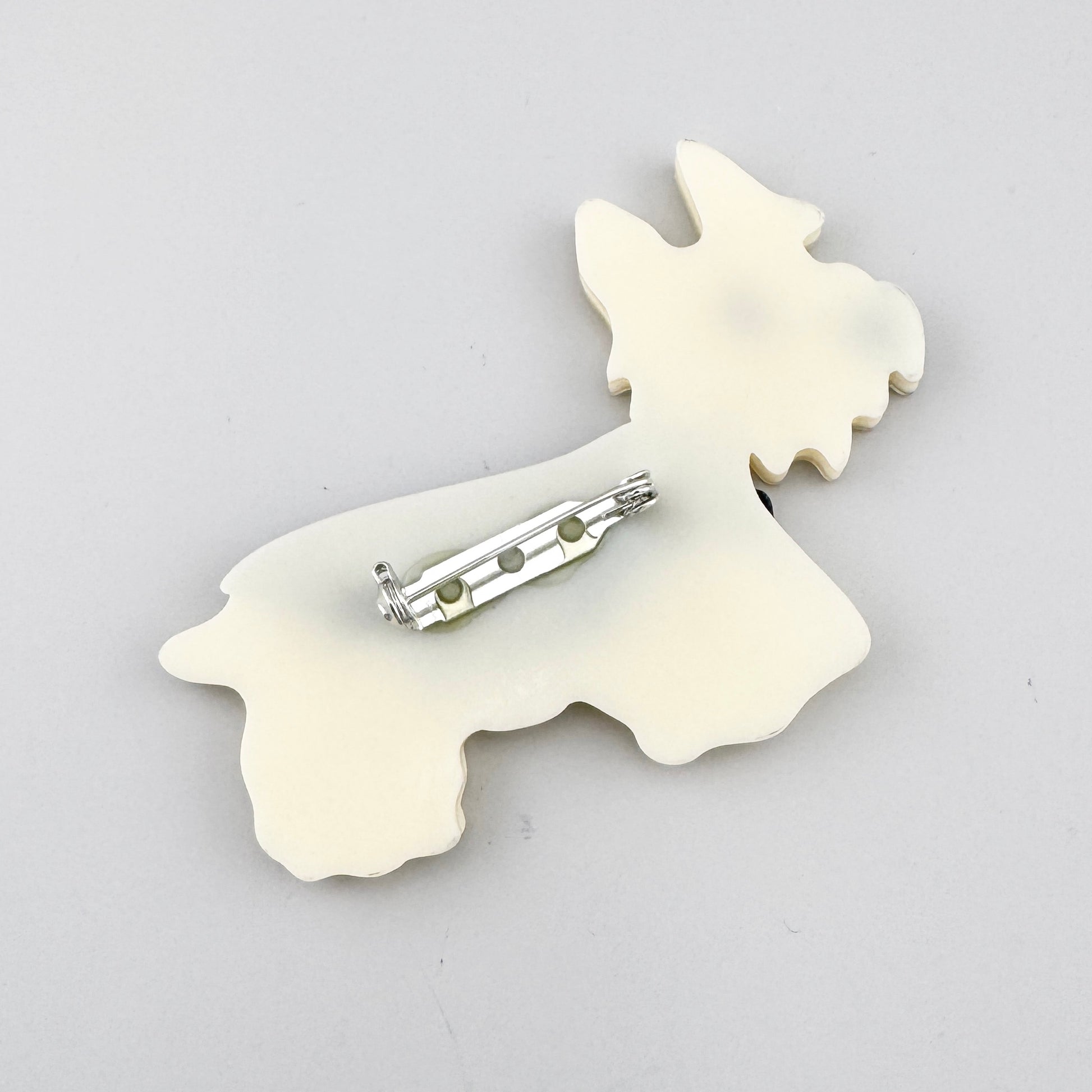 Brosche in Form eines Hundes aus perlmuttfarbenem Acryl mit Mosaikstruktur und gestreifter Weste, spanische Marke Sonata.