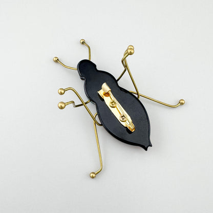 Brosche in Form eines stilisierten Insekts aus gefärbtem Acryl und goldfarbenem Metall, spanische Marke Sonata.