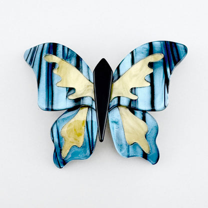 Butterfly-shaped brooch with a marbled effect in shades of blue and yellow, Spanish brand Sonata.