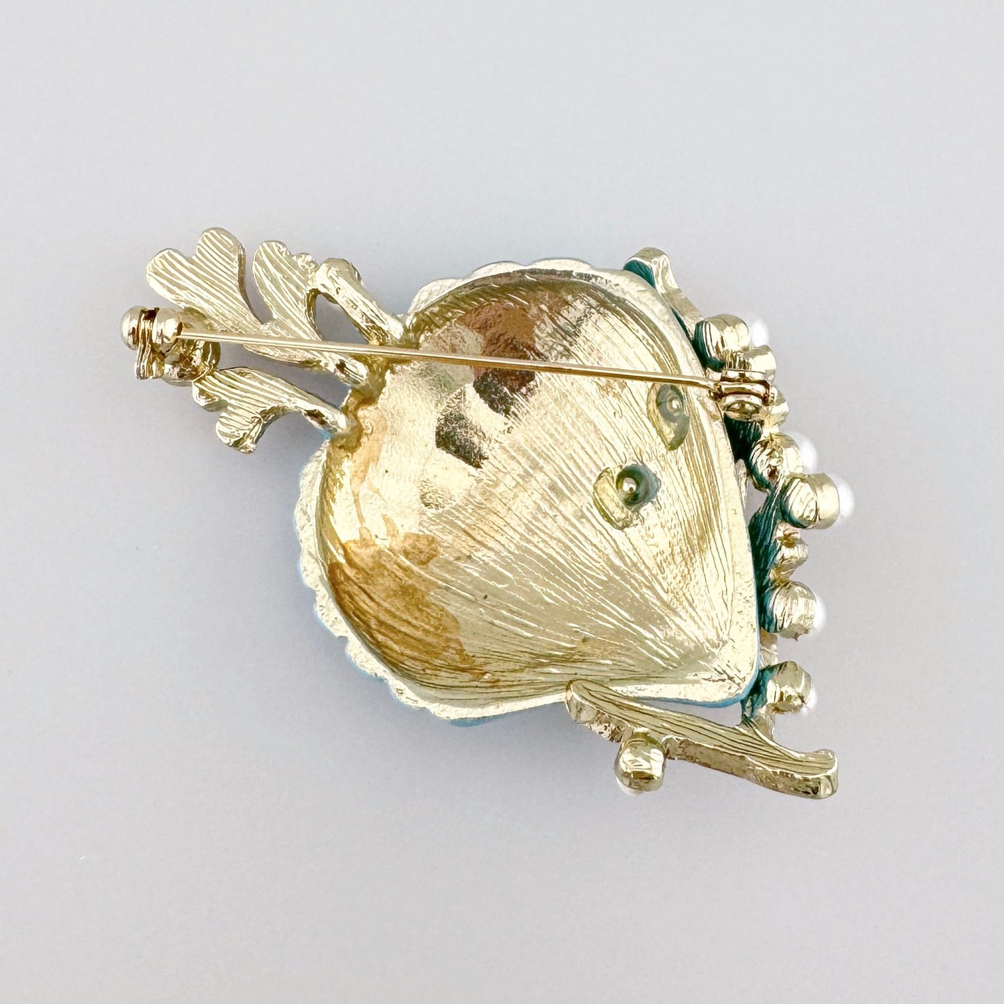 Broche en forme de coquillage avec émail bleu, ornée de corail et de perles.