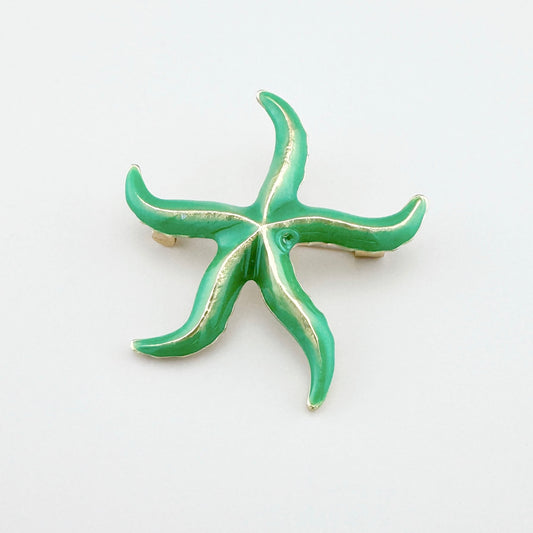 Green starfish brooch with shiny gold accents.