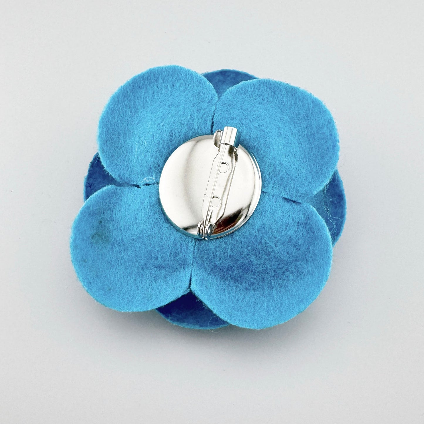 Broche en forma de flor azul de fieltro hecho a mano, marca española Sonata.