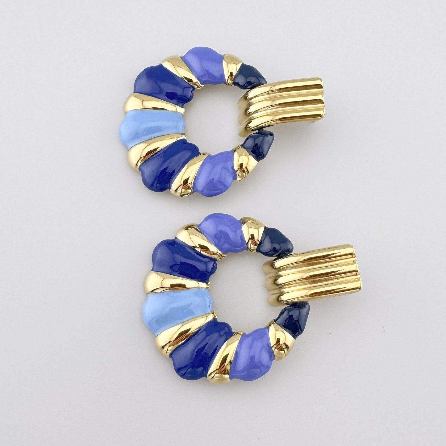 Gold earrings with enamel accents in various shades of blue.