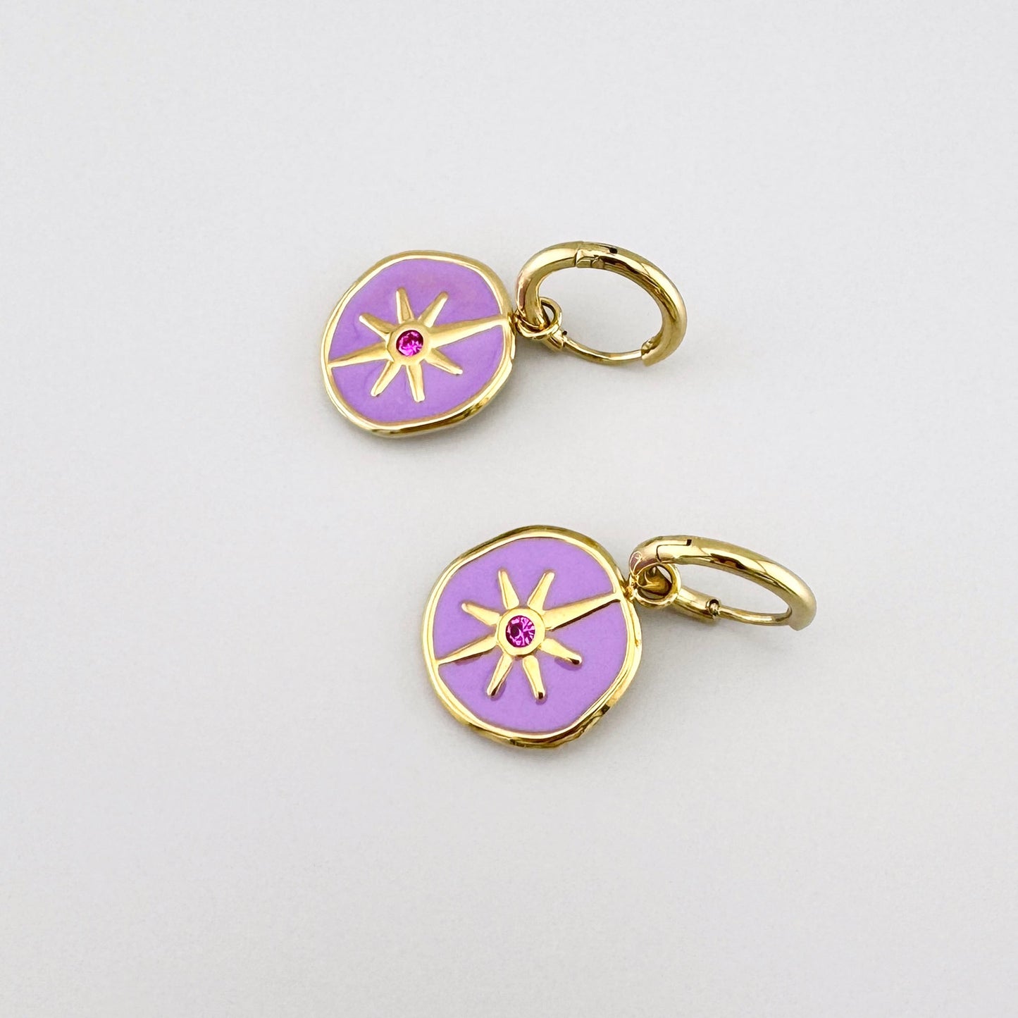 Gold earrings with purple enamel and a pink crystal, featuring a star motif.