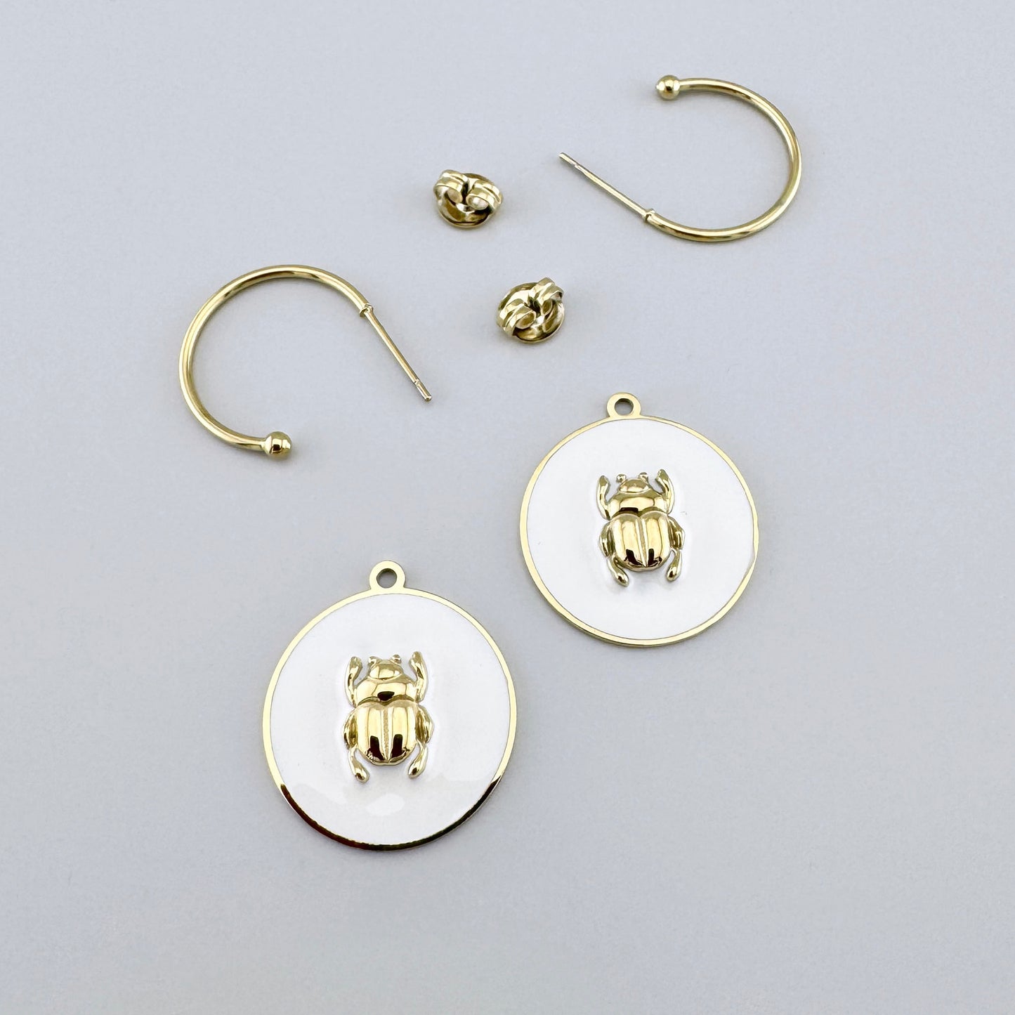 Earrings with white enamel and a gold beetle motif, French brand Ikita.