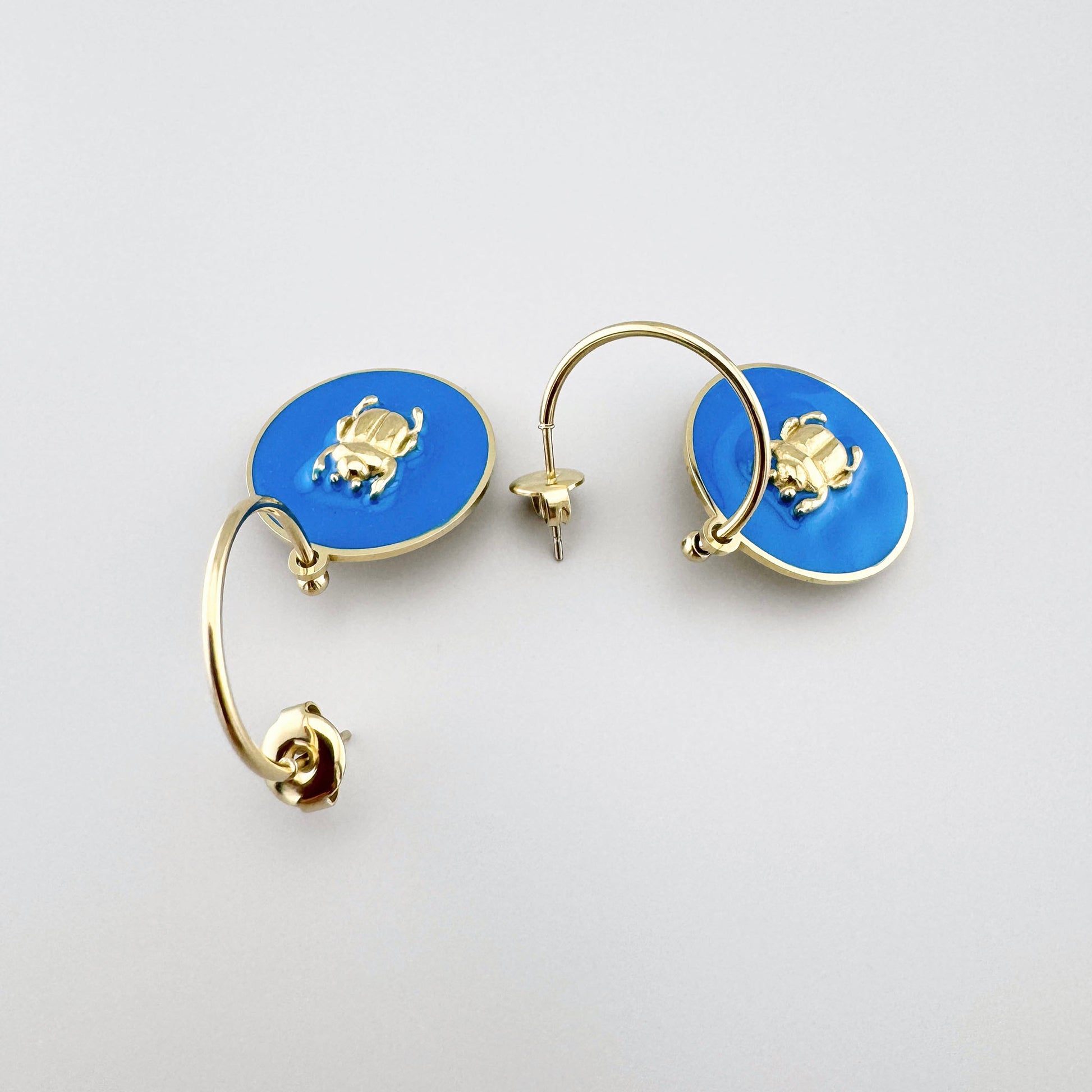 Hoop earrings with blue enamel and a gold beetle motif, French brand Ikita.