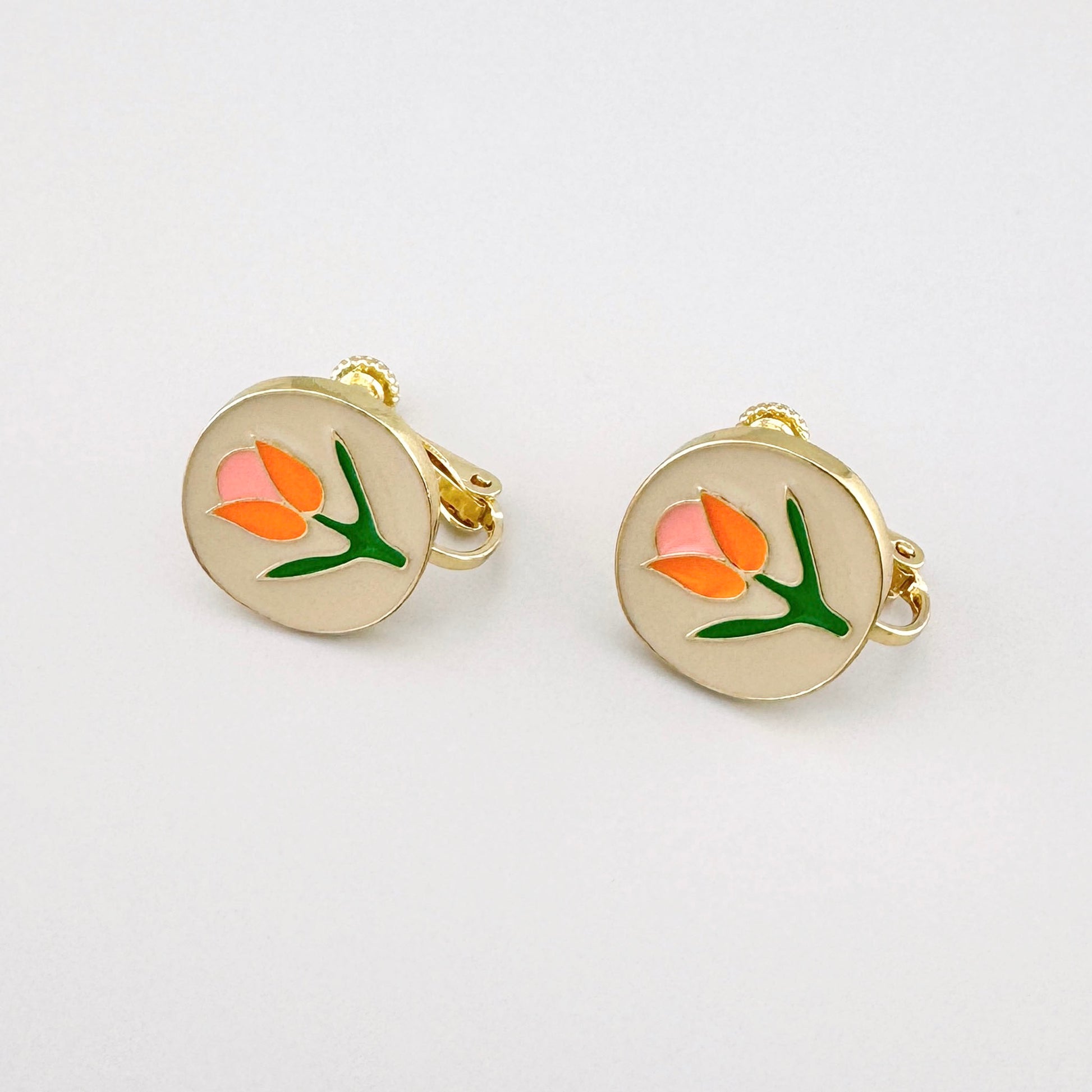 Floral clip-on earrings with pink, orange, and green details on a gold-tone base.