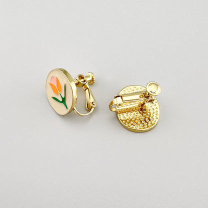 Pendientes de clip con motivo floral en tonos rosa, naranja y verde sobre base dorada.