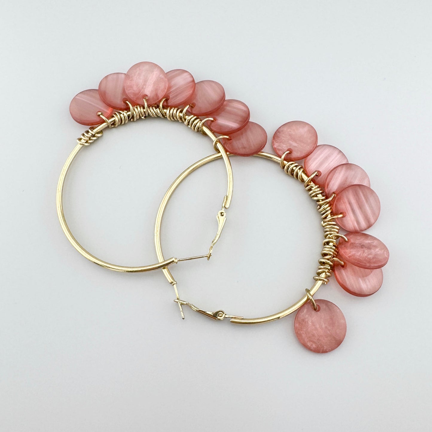 Large gold hoop earrings with pink pendants, Spanish brand Sonata.