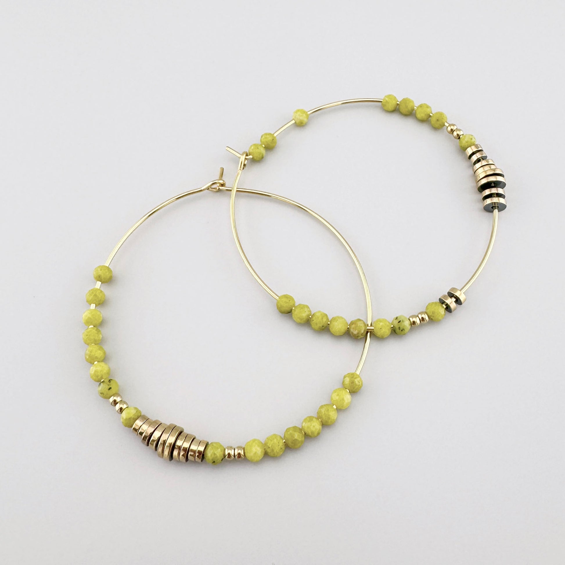 Hoop earrings with green stones and gold accents, French brand Ikita.